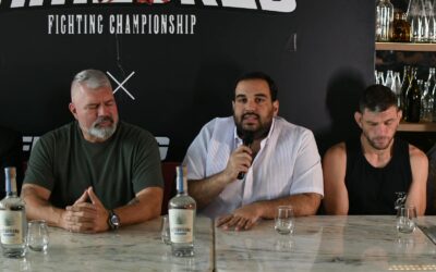 Rodolfo Dauhajre, junto a Lex McMahon y uno de los atletas, ofrece detalles en la rueda de prensa.